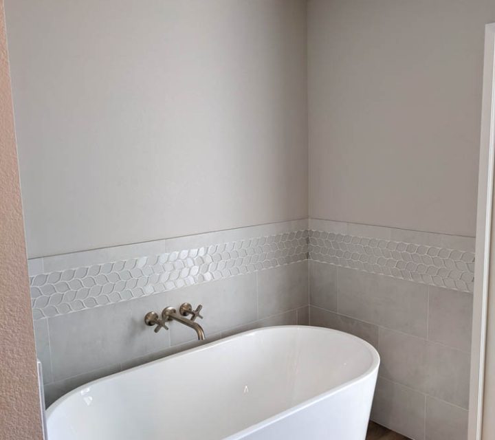 bathroom remodel, single bathtub with tile walls and hardwood floor