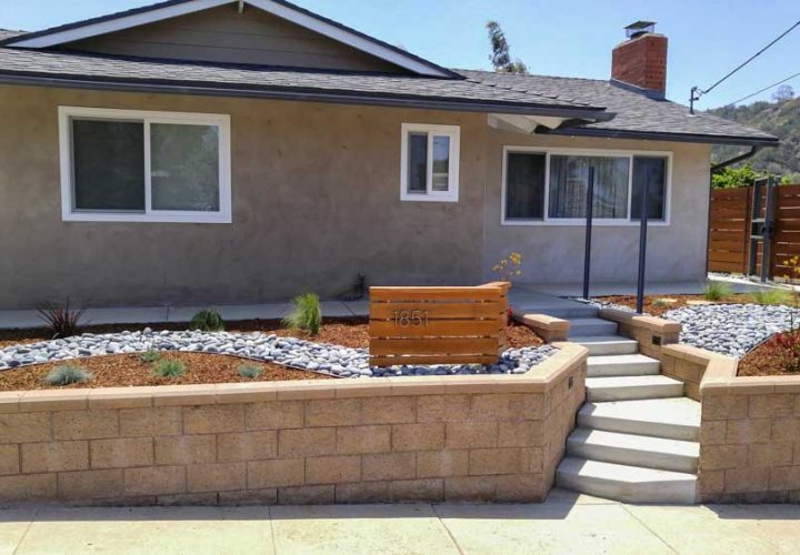 front view of a new house construction with a unique landscape, concrete steps and retaining walls